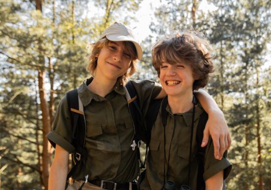 twee jongens in scoutsuniform in bos