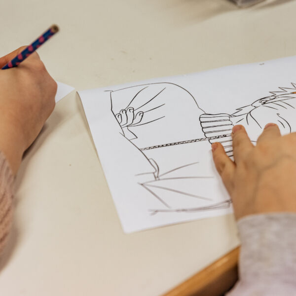 Tekenende kinderhanden maken tekeningen met zwart potlood