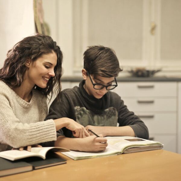 Moeder helpt zoon met huiswerk in de keuken