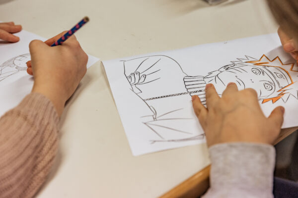 Tekenende kinderhanden maken tekeningen met zwart potlood